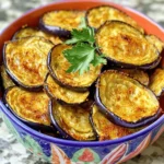 - 1 large eggplant - 2 tablespoons extra virgin olive oil - 1 teaspoon garlic powder - 1 teaspoon smoked paprika - ½ teaspoon sea salt - ½ teaspoon freshly ground black pepper - Optional: ½ teaspoon cayenne pepper for an extra kick Baked eggplant chips are not just tasty; they are also good for you. Each serving is about 100 calories. The macronutrient breakdown is roughly 2 grams of protein, 8 grams of fat, and 7 grams of carbs. These chips are low in calories and high in fiber, making them a smart snack choice. The eggplant is rich in vitamins and minerals. It has antioxidants that help fight free radicals in the body. This makes baked eggplant chips a healthier option compared to regular potato chips. By choosing fresh ingredients, you can make a snack that is both crunchy and nutritious. Follow the Full Recipe to enjoy these crispy treats! 1. Preheat your oven to 425°F (220°C). This hot oven helps the chips become crispy. 2. Rinse the eggplant under cold water. Remove any dirt, then slice it into rounds. Aim for about 1/8 inch thick. Thin slices cook better. 3. Place the eggplant rounds in a colander. Sprinkle them with salt. This draws out moisture and reduces bitterness. Let them sit for about 30 minutes. 1. In a large bowl, mix olive oil, garlic powder, smoked paprika, sea salt, black pepper, and optional cayenne pepper. Stir until well combined. 2. Add the rinsed and dried eggplant slices to the bowl. Toss gently. Make sure each slice gets coated with the tasty mixture. 1. Lay the coated eggplant slices on a baking sheet. Arrange them in a single layer. Avoid overlapping for maximum crispiness. 2. Place the baking sheet in the oven. Bake for 20-25 minutes. Halfway through, flip the slices. This helps them cook evenly. 3. Once they are golden and crispy, take them out. Let the chips cool on the baking sheet for a few minutes. This cooling time helps them firm up and adds a nice crunch. For the full recipe, check out the instructions above. Enjoy your tasty baked eggplant chips! To make your eggplant chips crispy, slice them evenly. Aim for about 1/8 inch thick. This uniform thickness ensures they cook at the same rate. If the slices are too thick, some may end up soggy. Also, lay the slices out in a single layer on the baking sheet. This step prevents them from overlapping, which can trap steam and make them soft. Get creative with flavors! While I love the mix of garlic powder and smoked paprika, you can try other seasonings. Consider using Italian herbs like oregano or basil for a twist. You can also sprinkle on some nutritional yeast for a cheesy flavor. A dash of lemon zest can brighten up the chips too. Experimenting with flavors makes this snack even more fun! Be careful not to over-season your eggplant slices. Too much salt or spice can overpower the natural taste. It’s best to start with a light hand and adjust as needed. Another mistake is not drying the eggplant properly after salting. If you skip this step, excess moisture can lead to chewy chips instead of crispy ones. Make sure to pat them dry well before baking. For the full recipe, check out the detailed instructions above. {{image_4}} You can easily change up the flavors of your baked eggplant chips. One way is by adding parmesan cheese. Just sprinkle some grated parmesan on the eggplant slices before baking. This will give your chips a cheesy, savory taste. You can also try different spices. Instead of garlic powder and smoked paprika, use herbs like oregano or thyme. A dash of cumin or chili powder can add a nice kick too. Mix and match according to your taste. For a healthier option, consider using an air fryer instead of baking. Air fryers use hot air to cook food, making it crispy with less oil. Adjust the cooking time to about 15-20 minutes at 400°F (200°C) for perfect results. If you need gluten-free options, you’re in luck! This recipe is naturally gluten-free. Just ensure that any added seasonings are also gluten-free. This makes it easier for everyone to enjoy the chips. Baked eggplant chips pair well with many dips. Hummus or tzatziki are great choices. They add flavor and creaminess to your snack. You can also serve them with salads. Slice the chips and add them as a crunchy topping on your favorite salad. For a fun side dish, serve these chips alongside grilled meats or roasted veggies. They add a unique twist to your meal. Try these ideas and see which pairings you enjoy the most. For the full recipe, check out the detailed instructions above. To keep your baked eggplant chips fresh, store them in an airtight container. This helps keep moisture out and maintains their crunch. They will stay fresh for about 3 to 5 days. If you want to keep them longer, consider placing them in the fridge. However, they may lose some crispiness over time. When you’re ready to enjoy your leftover chips, the key is to reheat them in the oven. Preheat your oven to 350°F (175°C). Spread the chips on a baking sheet in a single layer. Heat for about 5 to 10 minutes. This will help them regain their crispiness. You can also serve baked eggplant chips with fresh toppings. Try adding some salsa or guacamole for a fun twist. Enjoy your crispy snack! For the full recipe, check out the detailed instructions above. Salting the eggplant is key. When you slice the eggplant, sprinkle it with salt and let it sit. This draws out moisture and bitterness. After about 30 minutes, rinse the slices well. Pat them dry with paper towels. This makes a big difference in taste. Yes, you can use an air fryer! For the best results, set it to 375°F (190°C). Cook for about 15 to 20 minutes. Check them halfway through and shake the basket. This helps them cook evenly. Baked eggplant chips go well with many dips! Try classic hummus for a creamy taste. Tzatziki adds a cool flavor. You can also use guacamole or a spicy salsa. Each dip adds its own fun twist. Absolutely! You can try zucchini, sweet potatoes, or even beets. Just slice them thin, salt them, and follow the same steps. Each veggie brings its own flavor and crunch. Feel free to experiment! Baking eggplant chips is simple and fun. You only need a few key ingredients and clear steps. Remember to salt your eggplant well to draw out moisture. Aim for uniform thickness to achieve that perfect crispiness. Explore different seasonings to find what you love. Store leftovers properly and enjoy them later with your favorite dips. Making these chips can boost your snack game and add a healthy twist. Try them out, and you'll see how tasty they can be!