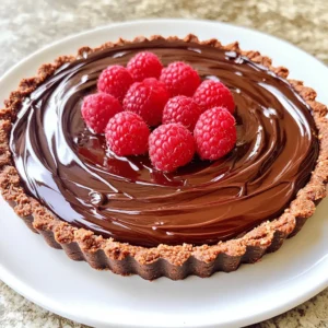 - 1 ½ cups chocolate cookie crumbs - ½ cup unsalted butter, melted - 1 cup dark chocolate chips (preferably 60% cocoa) - 1 cup heavy cream - 1 teaspoon vanilla extract - Pinch of sea salt - 1 cup fresh raspberries (plus extra for garnish) - 2 tablespoons powdered sugar The ingredients for this No Bake Raspberry Chocolate Tart are simple yet rich. The chocolate crust forms a great base. You can use chocolate cookie crumbs, like Oreos or digestive biscuits. Melted unsalted butter helps bind it together. The chocolate filling is where the magic happens. Dark chocolate chips give depth to the flavor. I prefer 60% cocoa for a nice balance. Heavy cream makes it smooth and creamy, while vanilla extract adds warmth. Just a pinch of sea salt brings out the chocolate taste. The raspberry puree adds a fresh twist. You need fresh raspberries for this. They offer a bright and tangy flavor. Mixing them with powdered sugar creates a delightful puree. The sweetness of the sugar balances the tartness of the berries perfectly. These ingredients work together to create layers of flavor. You’ll have a rich chocolate filling combined with a fruity raspberry twist. Each bite is a burst of delight! First, grab a medium bowl. Combine 1 ½ cups of chocolate cookie crumbs with ½ cup of melted butter. Use a fork or a spatula to mix until every crumb is coated. This step is key for a tasty crust. Next, take a 9-inch tart pan and pour the crumb mixture inside. Press it firmly into the bottom and up the sides. Make sure it forms an even layer with no gaps. Now, chill the crust in the fridge for 10-15 minutes. This helps it set properly. While the crust chills, let’s make the filling. In a small saucepan, heat 1 cup of heavy cream over medium heat. Watch closely as it simmers. Once it bubbles, take it off the heat. Add 1 cup of dark chocolate chips to the hot cream. Let them sit for 2-3 minutes. This softens the chocolate. Then, stir gently until the mix is smooth and shiny. Add 1 teaspoon of vanilla extract and a pinch of sea salt. Mix well to combine all the flavors. Now, let’s make the raspberry puree. Take 1 cup of fresh raspberries and put them in a bowl. Add 2 tablespoons of powdered sugar. Use a fork to mash the raspberries gently. You want a chunky puree, so don’t overdo it. Some pieces should stay intact for texture. It’s time to put it all together! Carefully fold the raspberry puree into the chocolate filling. Be gentle to keep some raspberry chunks. Then, pour this mixture into the chilled crust. Use a spatula to smooth the top. This gives it a nice finish. Place the tart in the refrigerator for at least 4 hours. This helps it firm up and set completely. The wait is worth it for the perfect no-bake dessert! To make the crust just right, you need to coat the crumbs well. Mix the chocolate cookie crumbs and melted butter until they feel moist. This keeps your crust from falling apart. When you press the mixture into the tart pan, do it firmly. Make sure it is even and packed tight. If it’s loose, the tart will crumble when you slice it. When you heat the heavy cream, watch it closely. You want it to simmer but not boil. After removing it from heat, add the dark chocolate chips. Let them sit for 2-3 minutes. This helps them melt without burning. Stir gently until the mix is smooth and glossy. It should look shiny and rich. Add the vanilla extract and a pinch of sea salt to enhance the flavor. To make your tart look stunning, add fresh raspberries on top. You can also add a dollop of whipped cream. This adds a nice touch and makes the tart look fancy. A light drizzle of chocolate sauce can also elevate your dish. Enjoy the beautiful mix of red and dark brown. It makes for a delightful dessert! {{image_4}} You can change the flavor of your No Bake Raspberry Chocolate Tart easily. Try using graham cracker crumbs instead of chocolate cookie crumbs. This swap gives a nice, sweet crunch. If you want a fun twist, add almond or mint extract to the chocolate filling. Just a few drops can brighten the taste and add charm. Want to mix it up? Incorporate nuts like chopped hazelnuts or almonds into the filling for a bit of crunch. You can also add different berries, such as strawberries or blueberries. These options give you a new taste, while keeping the tart fresh and exciting. You can make mini tarts or bite-sized pieces for a fun presentation. Use small tart pans or muffin tins to shape them. These smaller portions are great for parties or gatherings. You can also serve them on a big platter, making it easy for guests to grab one. Enjoy the fun of personalizing this delightful dessert! You can store your no-bake raspberry chocolate tart in the fridge. Use an airtight container to keep it fresh. If you want to freeze it, wrap the tart tightly in plastic wrap. Then, place it in a freezer bag. This will help prevent freezer burn. The tart lasts for about 5 days in the fridge. Make sure to keep it covered. If frozen, it can last up to 2 months. Just remember to thaw it overnight in the fridge before serving. Reheating is not usually needed for this tart. It tastes best when chilled. If you want to serve it warm, let it sit at room temperature for about 10 minutes. This will soften the chocolate slightly without losing its texture. Yes, you can use frozen raspberries. They work, but fresh raspberries taste better. Frozen berries may be softer after thawing. They can also add extra moisture to your tart. If you choose frozen, drain any excess water. This helps keep the tart from becoming soggy. Absolutely! You can make this tart dairy-free. Swap the heavy cream for coconut cream. Use dairy-free chocolate chips instead of dark chocolate chips. These changes keep the taste rich and delicious. Look for brands that have no dairy. This way, you can enjoy the tart without dairy. To make this tart gluten-free, choose gluten-free cookies for the crust. Look for brands that offer gluten-free chocolate cookies. You can also use crushed gluten-free graham crackers. Ensure all your ingredients are labeled gluten-free. This way, everyone can enjoy your tart without worry. Yes, you can prepare the tart ahead of time. Make it a day before serving for the best taste. Keep it in the fridge to let it set. This helps the flavors blend well. When ready to serve, garnish it with fresh raspberries. It will look beautiful and taste fresh! This blog post covered how to make a delicious chocolate raspberry tart. You learned about the key ingredients, from the chocolate crust to the raspberry puree. I shared step-by-step instructions to guide you through each part. With tips on perfecting your tart and fun variations, you can get creative and make it your own. Remember, this tart is tasty and easy to customize. Enjoying it with friends or family will make it even better. Happy baking!