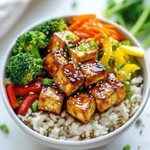 - 1 block (14 oz) firm tofu, pressed and cubed - 1 cup brown rice - 2 cups vegetable broth (or water) - 1 cup broccoli florets - 1 bell pepper, sliced (your choice of color) - 1 carrot, julienned - 2 tablespoons vegetable oil - 1 tablespoon sesame oil - 4 tablespoons soy sauce - 2 tablespoons mirin (or substitute with additional honey or agave syrup) - 2 tablespoons honey (or agave syrup for a vegan option) - 1 teaspoon freshly grated ginger - 1 garlic clove, minced In this dish, tofu and brown rice serve as the base. Tofu is a great source of protein. It absorbs flavors well and adds texture. Brown rice is nutty and filling, making it a perfect pairing. - 1 tablespoon sesame seeds - Chopped green onions These garnishes add extra flavor and a nice crunch. They also make your dish look beautiful! - For a vegan option, use agave syrup instead of honey. - For a gluten-free choice, replace soy sauce with tamari sauce. These substitutions keep the dish tasty and suitable for different diets. You can enjoy this meal no matter your dietary needs. {{ingredient_image_2}} - Rinsing the Rice Start by rinsing 1 cup of brown rice. Use cold water until it runs clear. This step removes excess starch. It helps the rice cook better. - Cooking Process In a pot, mix the rinsed rice with 2 cups of vegetable broth. Bring it to a boil. Then, reduce the heat and cover. Let it simmer for about 45 minutes. The rice is ready when it's tender and the liquid is absorbed. Fluff it with a fork and set aside. - Ingredients Mixing In a small bowl, whisk together 4 tablespoons of soy sauce, 2 tablespoons of mirin, and 2 tablespoons of honey. Add 1 teaspoon of grated ginger and 1 minced garlic clove. Mix well until combined. - Setting Aside Set the teriyaki sauce aside for later. This sauce adds rich flavor to the tofu. - Heating the Oil Heat 2 tablespoons of vegetable oil in a large skillet over medium-high heat. Wait until the oil shimmers. - Sautéing the Tofu Add the cubed tofu to the skillet. Sauté for about 5-7 minutes. Turn the tofu occasionally until all sides are golden and crispy. This gives it a nice texture. - Heating Sesame Oil In another skillet, heat 1 tablespoon of sesame oil over medium heat. This oil adds a nice flavor to the veggies. - Cooking Techniques Add broccoli florets, sliced bell pepper, and julienned carrot to the pan. Stir-fry for about 5 minutes. Cook until the veggies are bright and slightly crunchy. This keeps them fresh and colorful. - Layering Ingredients Start with a scoop of brown rice at the bottom of each bowl. Then, layer the glazed tofu on top. - Garnishing the Dish Add a colorful mix of stir-fried vegetables on top. Finish with toasted sesame seeds and chopped green onions. This not only adds flavor but also makes the dish look beautiful. Pressing Techniques Pressing tofu is key for a great texture. Start with firm tofu for the best results. Wrap the tofu block in a clean kitchen towel. Place a heavy object, like a cast-iron pan, on top. Let it sit for at least 30 minutes. This removes excess water, making the tofu firmer and ready to absorb flavors. Cooking Tips for Crispiness For crispy tofu, cut it into small cubes. Heat vegetable oil in a skillet over medium-high heat. Once hot, add the tofu cubes. Cook for 5 to 7 minutes, flipping to brown all sides. This ensures a nice golden crust. Don't overcrowd the pan; it can cause steaming instead of crisping. Additional Spices While teriyaki sauce is fantastic, you can add spices for more depth. A pinch of red pepper flakes gives heat. A dash of five-spice powder adds warmth and richness. You can also sprinkle some black sesame seeds for a nutty flavor. Flavor Pairings Pairing tofu with fresh ginger and garlic enhances the dish. They add brightness and zest. Consider adding lime juice for a citrus twist. It elevates the flavors and makes the dish lively. Ideal Serve Temperature Serve your teriyaki tofu rice bowls hot. The warmth brings out the flavors in the tofu and veggies. If you make the bowls ahead, reheat them gently before serving. This keeps the textures enjoyable. Pairing with Other Dishes These rice bowls go well with a side of edamame or seaweed salad. They complement the flavors and add variety. For a complete meal, serve with a light miso soup. This combination creates a balanced and satisfying dining experience. Pro Tips Press the Tofu: Before cooking, make sure to press the tofu to remove excess moisture. This helps achieve a firmer texture and allows it to absorb the marinade better. Use Fresh Veggies: For the best flavor and texture, use fresh and vibrant vegetables. They not only enhance the dish visually but also add nutritional value. Customize the Sauce: Feel free to adjust the sweetness and saltiness of the teriyaki sauce by adding more honey or soy sauce according to your taste preferences. Garnish for Flavor: Don’t skip the sesame seeds and green onions! They provide a crunchy texture and fresh flavor that elevates the overall dish. {{image_4}} You can easily change the sauce in this dish. Try using hoisin sauce for a sweet twist. Or, use a spicy chili sauce for some heat. You can also make a simple soy sauce mix with lime juice. This keeps the dish fresh and exciting. For vegetables, feel free to mix and match. Snap peas, zucchini, or mushrooms add great flavor. You can also try adding corn for sweetness. Each choice brings a new taste to your bowl. If you want a twist, use quinoa instead of rice. Quinoa is full of protein and fiber. It also cooks faster than brown rice. This change makes your meal more nutritious and light. To cook quinoa, rinse 1 cup under cold water. Then, combine it with 2 cups of vegetable broth. Bring it to a boil and let it simmer for about 15 minutes. Fluff it with a fork, and it’s ready to use. If you love heat, add chili flakes or sriracha to your teriyaki sauce. Start with a small amount and taste as you go. This way, you can find the right heat for you. For ingredients, add jalapeños or spicy pickled vegetables. You can also try a drizzle of spicy sesame oil. These additions create a bold, exciting dish that packs a punch. After making teriyaki tofu rice bowls, let them cool to room temperature. Place leftovers in an airtight container. Store them in the fridge. They will stay fresh for about 3 to 5 days. To keep flavors intact, avoid mixing components until you're ready to eat. You can freeze teriyaki tofu rice bowls for later enjoyment. This is a great way to save time. - How to Freeze Properly: Allow the dish to cool completely. Portion it into individual servings. Use freezer-safe bags or containers. Remove as much air as possible to prevent freezer burn. Label each container with the date and contents. - Thawing and Reheating Instructions: To thaw, place the frozen bowl in the fridge overnight. For quick thawing, use the microwave on a low setting. Reheat in a pan over medium heat for even warming. Add a splash of water if needed to avoid dryness. Knowing when food spoils is important. Always check your leftovers before eating. - Noticing Signs of Spoilage: If you see mold, or if the food smells off, throw it away. A change in color can also indicate spoilage. - Tips for Freshness: Keep leftovers in airtight containers. Use them within a few days for the best taste. Always reheat food to a safe temperature before eating. Yes, you can make this dish ahead. It saves well in the fridge. Cool the bowls completely before storing. Use airtight containers for best results. They last about 3-4 days. Making it ahead helps the flavors meld together. The teriyaki sauce soaks into the tofu and rice. This adds more taste when you eat it later. Yes, teriyaki tofu is a healthy choice. It offers a good mix of nutrients. Tofu is high in protein and low in fat. Brown rice gives you fiber and energy. The vegetables add vitamins and minerals. This dish is balanced and satisfying. You can serve many sides with this dish. It pairs well with light salads or steamed veggies. Try a simple cucumber salad or edamame on the side. Both add freshness and crunch. For drinks, green tea or sparkling water works great. They enhance the meal without overpowering it. Yes, you can swap tofu with other proteins. Chicken, shrimp, or tempeh are great options. If you use chicken or shrimp, adjust cooking times. Cook them until just done. Tempeh needs similar treatment to tofu. Make sure to cook any protein thoroughly. Adjust the teriyaki sauce amounts if needed for flavor. In this blog post, we explored how to make delicious teriyaki tofu rice bowls. We covered essential ingredients like tofu, rice, and veggies, along with optional garnishes. Step-by-step, I guided you through cooking brown rice, making the teriyaki sauce, and sautéing the tofu and veggies. I also shared tips for perfection and variations to suit your needs. You now have the tools to create a tasty dish that fits your lifestyle. Enjoy these bowls and make them your own!