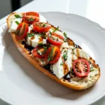 - 1 large baguette or ciabatta bread - 1/2 cup unsalted butter, softened - 4 cloves garlic, minced - 2 cups cherry tomatoes, halved - 8 ounces fresh mozzarella cheese, sliced The main ingredients bring rich flavors. The bread serves as a base. I love using a baguette for its crust. Ciabatta works great too, as it has a soft center. Butter adds creaminess, while garlic gives a punch. Minced garlic spreads its aroma throughout. Cherry tomatoes add sweetness. Their juicy nature complements the cheese. Fresh mozzarella melts beautifully for a creamy texture. - 1 teaspoon dried oregano - 1 teaspoon salt - Freshly cracked black pepper, to taste - Balsamic glaze, for drizzling These seasonings play a big role in flavor. Dried oregano adds an earthy taste. Salt brings out the natural flavors. Freshly cracked black pepper adds a slight heat. Drizzling balsamic glaze on top provides a sweet and tangy kick. It enhances the overall taste and makes it pop. - 1/4 cup fresh basil leaves, chopped Basil is a must for garnishing. Its fresh aroma brightens the dish. It adds a lovely green color too. I recommend using fresh basil leaves. They are fragrant and vibrant. You can chop them or leave them whole for a beautiful finish. {{ingredient_image_2}} To start, preheat your oven to 400°F (200°C). This step is key for nice, crispy bread. A hot oven will help the cheese melt perfectly and the edges turn golden. Next, we need to make the garlic butter. In a small bowl, mix together 1/2 cup of softened unsalted butter and 4 minced garlic cloves. Add 1 teaspoon of dried oregano and 1 teaspoon of salt. For some heat, sprinkle in freshly cracked black pepper. Stir until everything blends well into a smooth mixture. Now, take your baguette or ciabatta and slice it in half lengthwise. Place the halves on a baking sheet with the cut side facing up. Spread the garlic butter generously over each half. Make sure the butter covers every inch for maximum flavor. After that, layer 2 cups of halved cherry tomatoes on top. Finally, add 8 ounces of sliced fresh mozzarella cheese, spreading it evenly. Place your baking sheet in the preheated oven. Bake for about 10-12 minutes. Keep an eye on it! The mozzarella should be melted and bubbly, while the bread's edges turn golden brown. When it’s done, take the bread out of the oven. Immediately sprinkle 1/4 cup of chopped fresh basil leaves on top. This will make the aroma fantastic. To finish, drizzle some balsamic glaze over the bread. It adds a sweet and tangy taste. Now, slice the bread into pieces and serve warm. Enjoy your delicious Caprese Garlic Bread! To make the garlic butter even better, add fresh herbs. Chopped parsley or thyme works great. Mix these into the butter with garlic for a fresh taste. You can also try a pinch of red pepper flakes for a little heat. This adds depth and flavor to your garlic butter. When picking bread, consider taste and texture. A baguette has a crispy crust and soft inside. It holds toppings well and gives a nice crunch. Ciabatta is softer and chewier. It soaks up flavors and is great for a softer bite. Choose based on your preference for crunch or softness. Caprese garlic bread pairs well with many dishes. Try it with a fresh salad for a light meal. It also goes nicely with pasta. For drinks, serve with a chilled white wine or sparkling water. The flavors blend well and make for a delicious meal. Enjoy experimenting! Pro Tips Use Fresh Ingredients: Always opt for fresh mozzarella and ripe cherry tomatoes for the best flavor and texture. Customize the Seasoning: Feel free to add red pepper flakes or fresh herbs like thyme or rosemary for added depth of flavor. Monitor Baking Time: Keep an eye on the bread while it bakes to prevent burning, as oven temperatures can vary. Serve Immediately: This dish is best enjoyed fresh out of the oven while the cheese is melty and the bread is warm. {{image_4}} To make a vegan version of Caprese Garlic Bread, you can swap out the dairy ingredients. Use a plant-based butter instead of unsalted butter. For cheese, try a dairy-free mozzarella or a cashew-based cheese. These options melt well and keep the flavor intact. When it comes to the toppings, feel free to add extra veggies. Sliced olives or artichokes work great. They add a nice twist and keep the dish vibrant and fresh. You can boost the nutritional value of your Caprese Garlic Bread by adding more veggies. Sliced bell peppers, spinach, or even roasted zucchini can give your dish extra color and flavor. Try layering the veggies on top of the garlic butter before the tomatoes and cheese. This way, they roast beautifully while baking. It makes every bite more exciting and healthy. If you love some heat, add spicy elements to your bread. Sliced jalapeños or a sprinkle of red pepper flakes can bring a kick to the dish. Mix the spicy ingredients into the garlic butter for a subtle heat. Or, sprinkle them on top before serving. Either way, it adds a fun twist that will thrill those who enjoy spice! To keep your Caprese garlic bread fresh, follow these steps: - Refrigerate: Wrap the bread tightly in plastic wrap or aluminum foil. Store it in the fridge for up to 3 days. - Freeze: For longer storage, place the wrapped bread in a freezer bag. It can last up to 2 months. Make sure to remove as much air as possible. To restore the crispness and flavor, try these methods: - Oven: Preheat your oven to 350°F (175°C). Place the bread on a baking sheet and heat it for about 10 minutes. This will make the crust crispy again. - Air Fryer: If you have one, set it to 350°F (175°C) and heat for around 5 minutes. This gives a nice texture. Caprese garlic bread lasts: - In the fridge: Up to 3 days. - In the freezer: Up to 2 months. Check for any signs of spoilage before eating. Yes, you can make this dish ahead of time. Prepare the garlic butter and spread it on the bread. Layer the tomatoes and cheese, then cover it. Store it in the fridge for up to 24 hours. When ready to bake, just pop it in the oven. This saves time for busy days. Reheating garlic bread can be easy. Preheat your oven to 350°F (175°C). Place the bread on a baking sheet. Heat it for about 10 minutes. This method keeps the bread crispy. You can also use a toaster oven for a quicker option. Avoid using the microwave, as it makes bread soggy. Absolutely! While fresh mozzarella is classic, you can try other cheeses. Provolone or fontina work well too. If you like a stronger flavor, add some aged cheddar. Mixing cheeses can create a unique taste. Feel free to experiment based on your preference. To make Caprese Garlic Bread gluten-free, choose the right bread. Look for gluten-free baguettes or ciabatta. Many stores sell gluten-free options now. You can also use gluten-free flatbreads. Just follow the same steps in the recipe. Enjoy this tasty treat without worry! In this blog post, we explored how to make delicious Caprese Garlic Bread. We covered essential ingredients like baguette, butter, and garlic, along with easy step-by-step instructions. I shared tips for perfecting flavors and ideas for variations, such as vegan options or adding spicy elements. Proper storage and reheating tips ensure your leftovers stay tasty. With these techniques, you can impress anyone at your next meal. Enjoy crafting this flavorful treat!